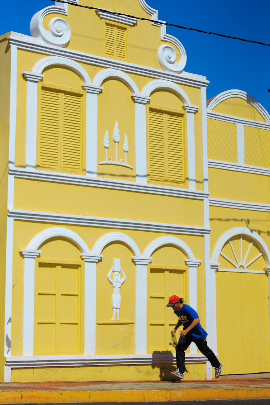 yellow historic building in willemstad curacao with shutters and decorative facade
