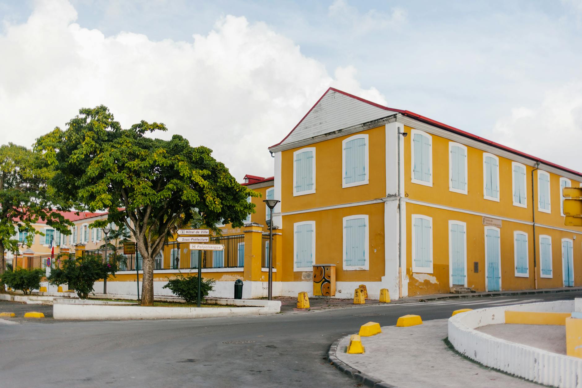 yellow house with blue shutters on quiet street in curacao caribbean neighborhood