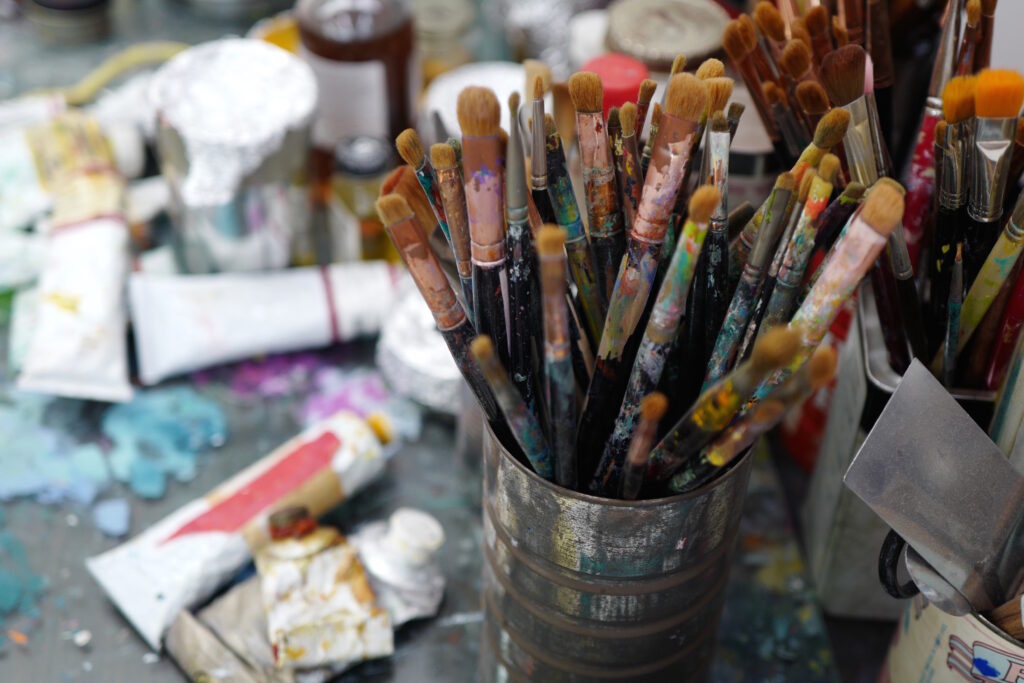 artist studio  paint brushes in tin can paint tubes