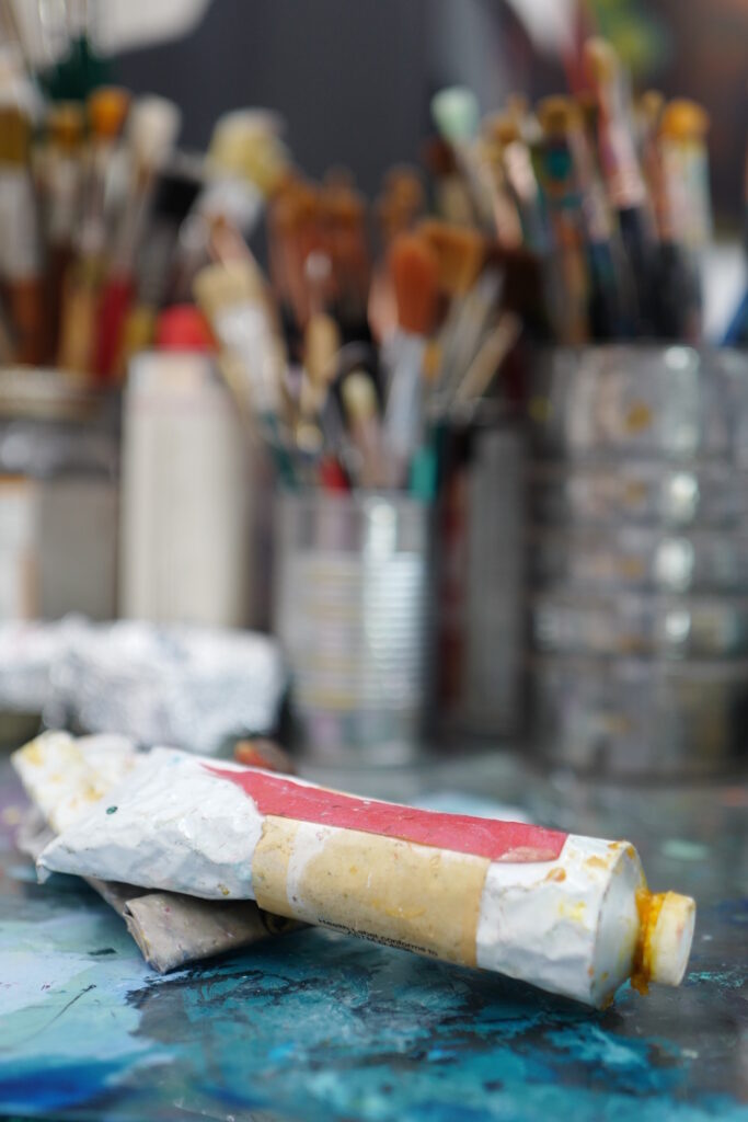 artist studio paint tube on palatte dof paintbrushes tin cans vertical