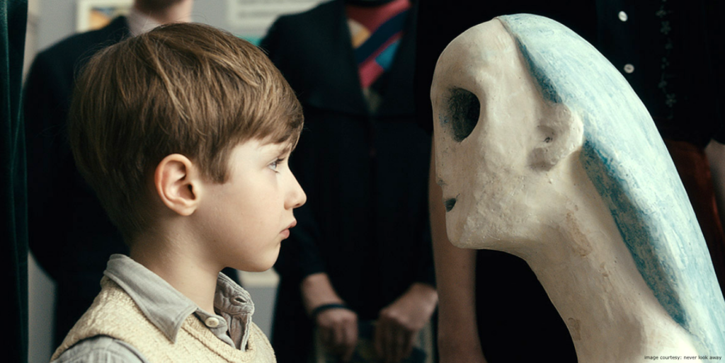 Never Look Away film still of the younger artist Kurt Schilling staring at a sculpture in a german gallery