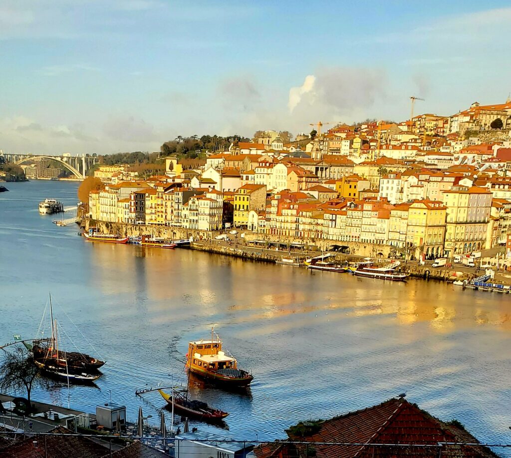 High-angle view of the Douro River with moored boats and a bridge, seen from Vila Nova de Gaia
